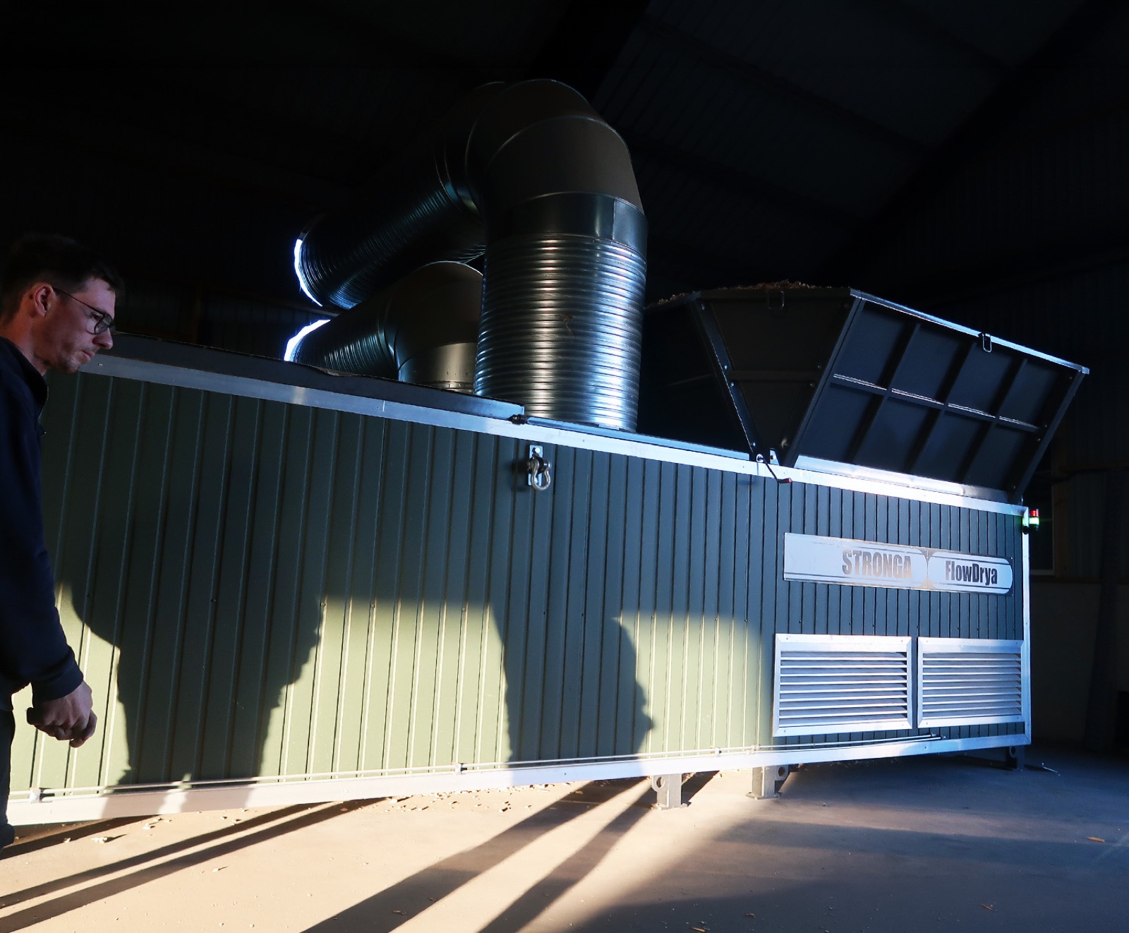 Engineer inspecting a FlowDrya miscanthus drying unit installed on-farm