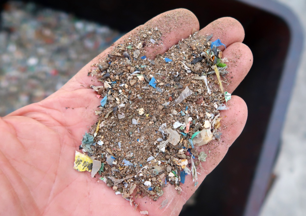 Sand grit and heavy fines particles screened from plastic packaging during FlowDrya flow drying process